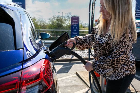 A person plugging an EV charger into a car