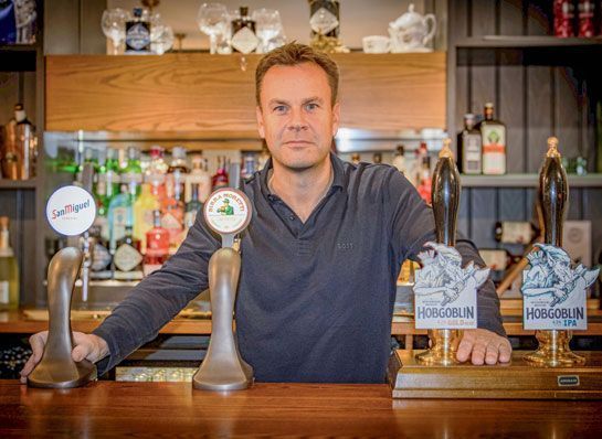 Photo of Justin Platt standing at a bar