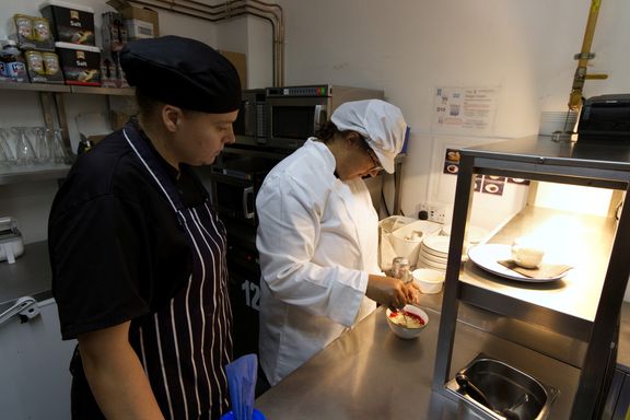 Chef supervising trainee in kitchen