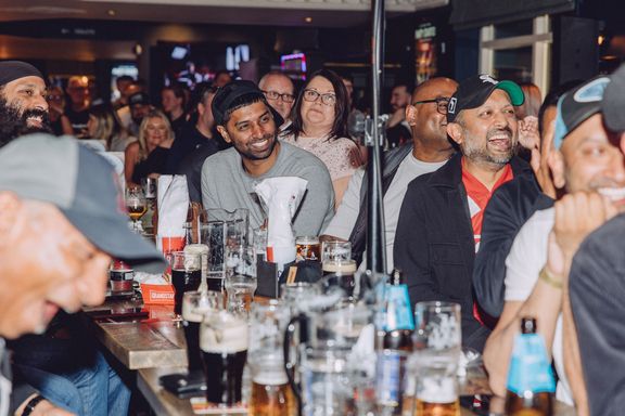 Crowd of pub customers watching a sporting event