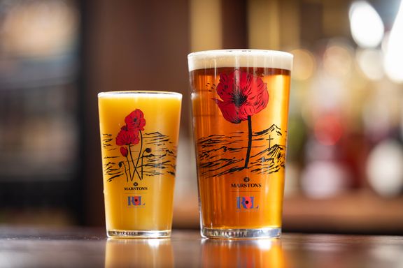 A commemorative half-pint glass and a commemorative pint glass on a bar