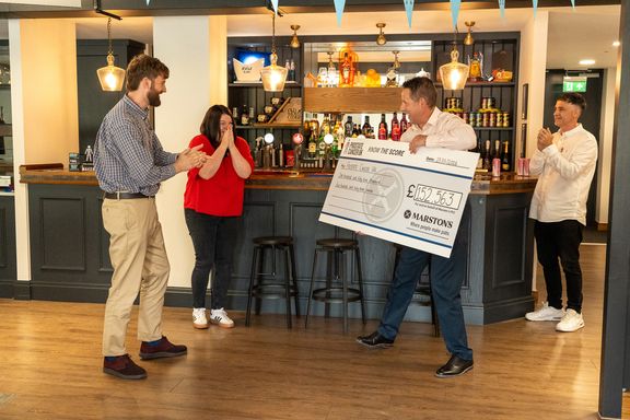 A cheque for £152,563 being presented