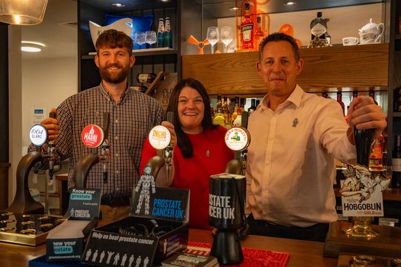 Three pub team members behind bar