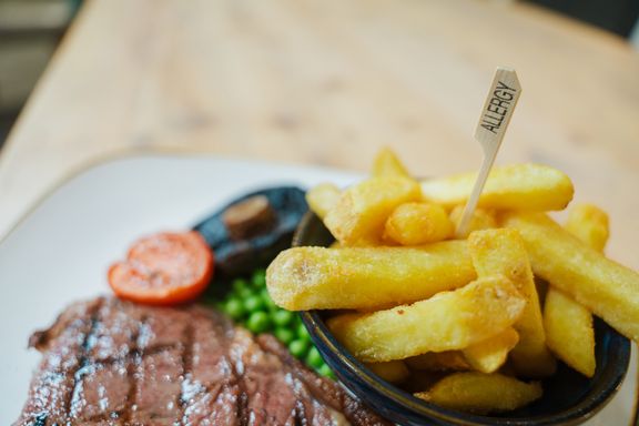 Steak and chips with a toothpick marked with the word allergy