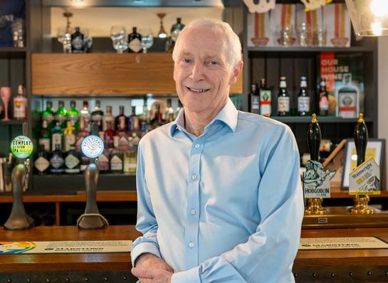 Photo of Ken Lever standing at a bar