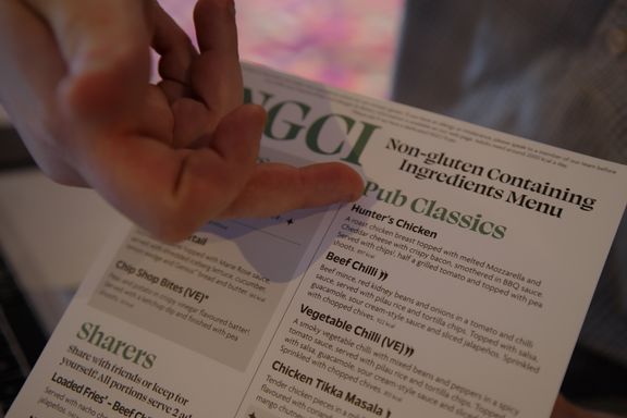A hand pointing to items on a non-gluten containing ingredient (NGCI) menu