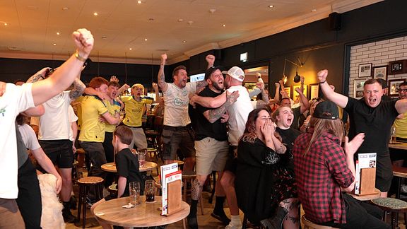 Sport fans celebrating in a pub